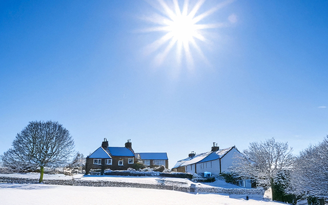 Wintery countryside with building covered in snow